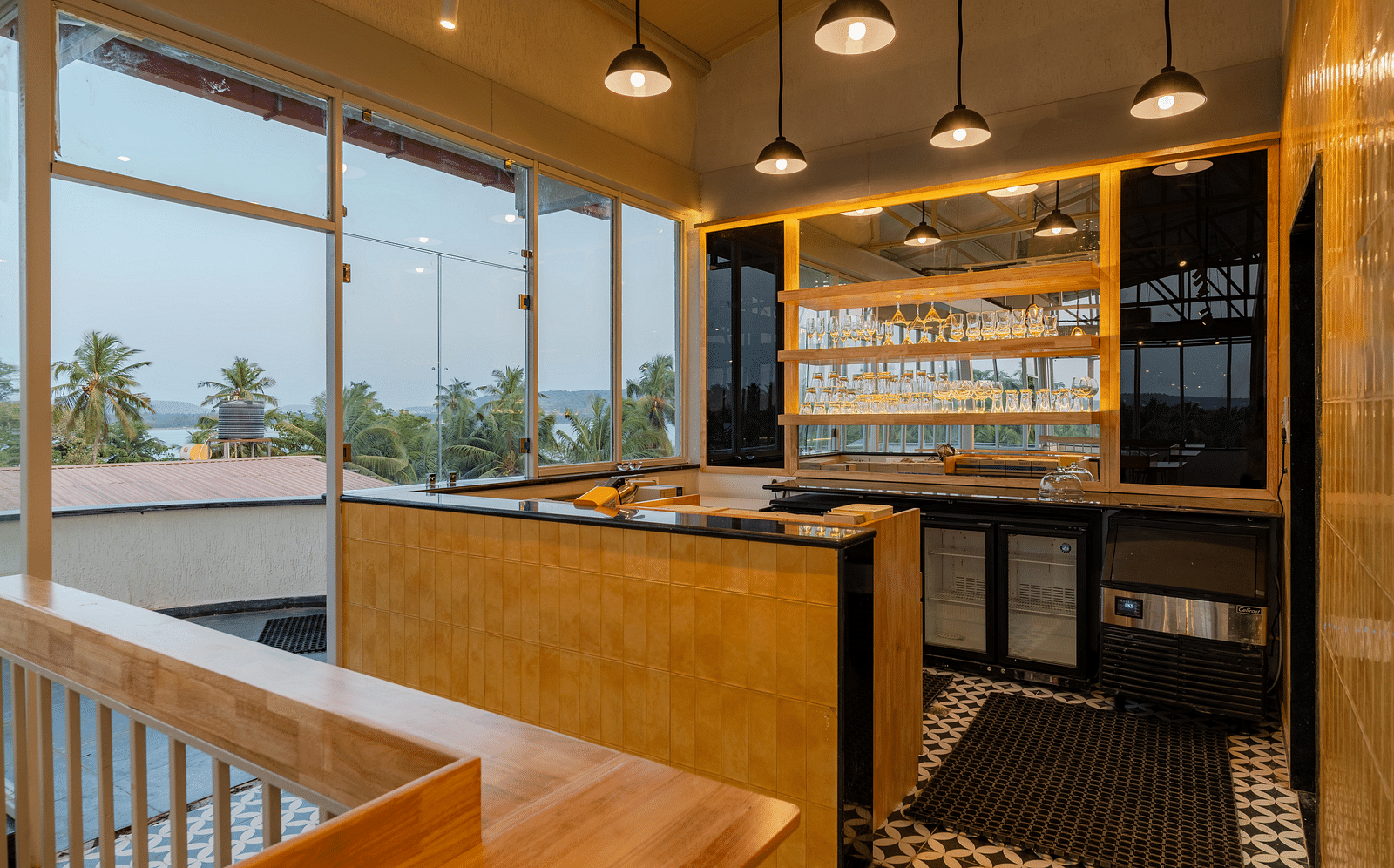 Interior of a contemporary cafe with bar stools and a window view. at Bedzzz Xclusiv Morjim, Goa
