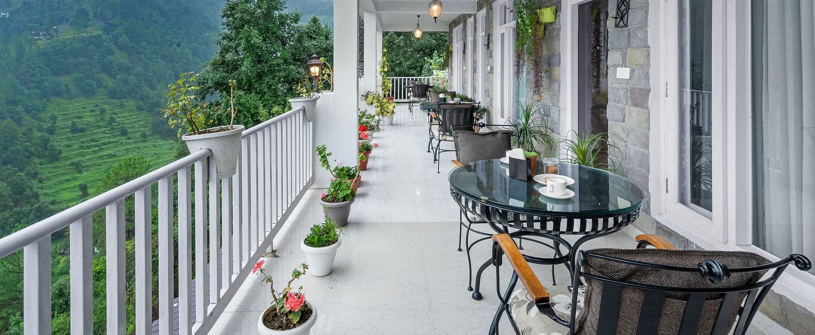 Long verandah with seating arrangements offering panoramic views of the mountains at BluSalzz Collection - Suvaasa Resort, Ramgarh.