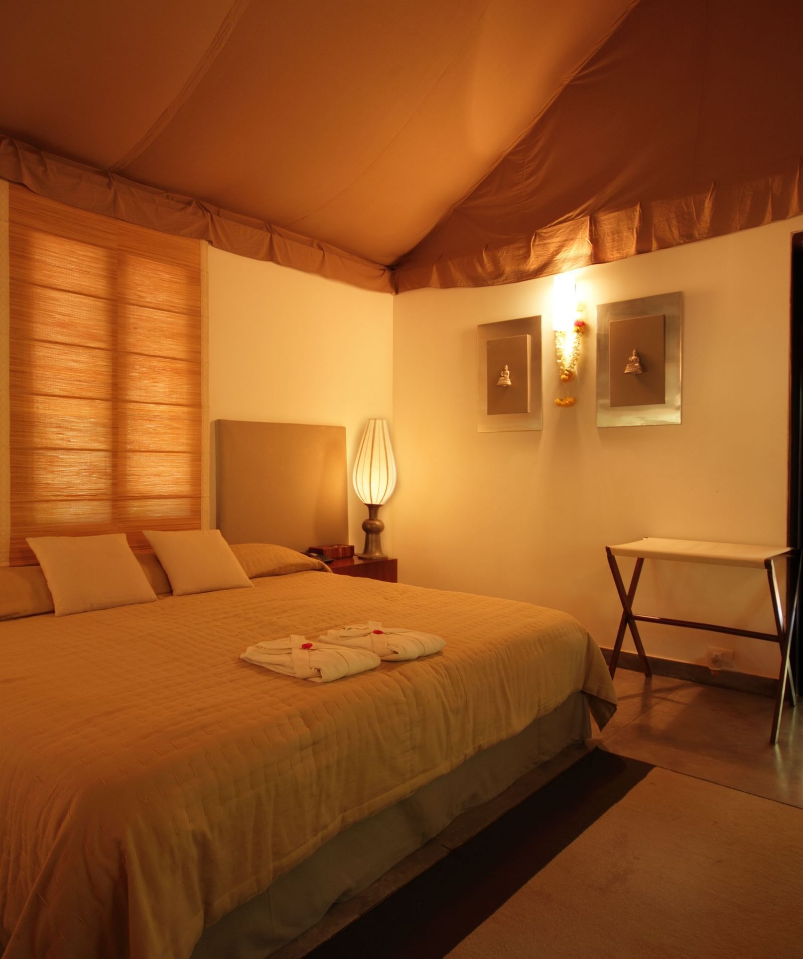 A bedroom with a bed, lamps, and a view of a garden - Shreyas Retreat