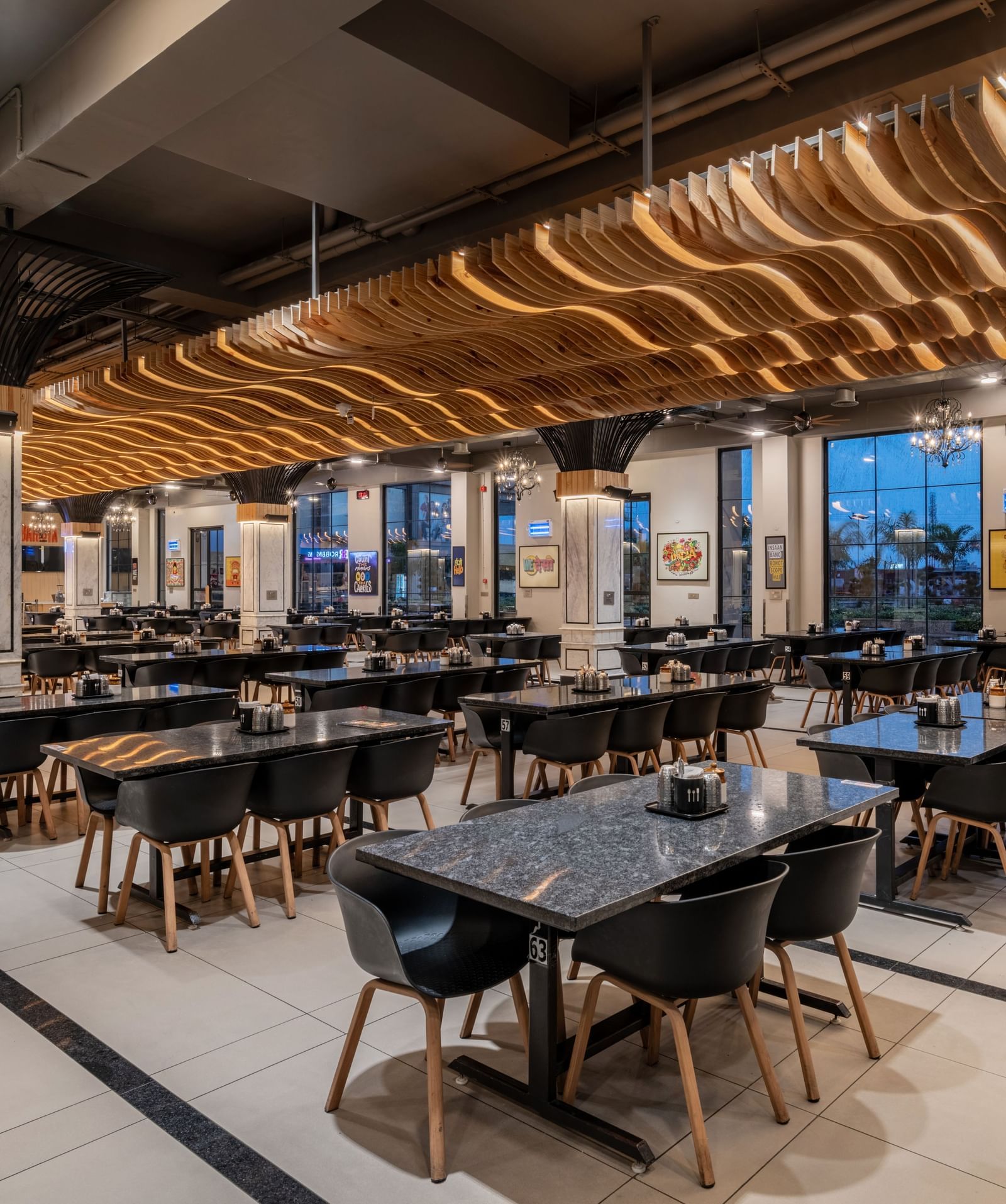 Restaurant seating area with arranged tables and illuminated ceiling at Hotel Highway King, Kishangarh.