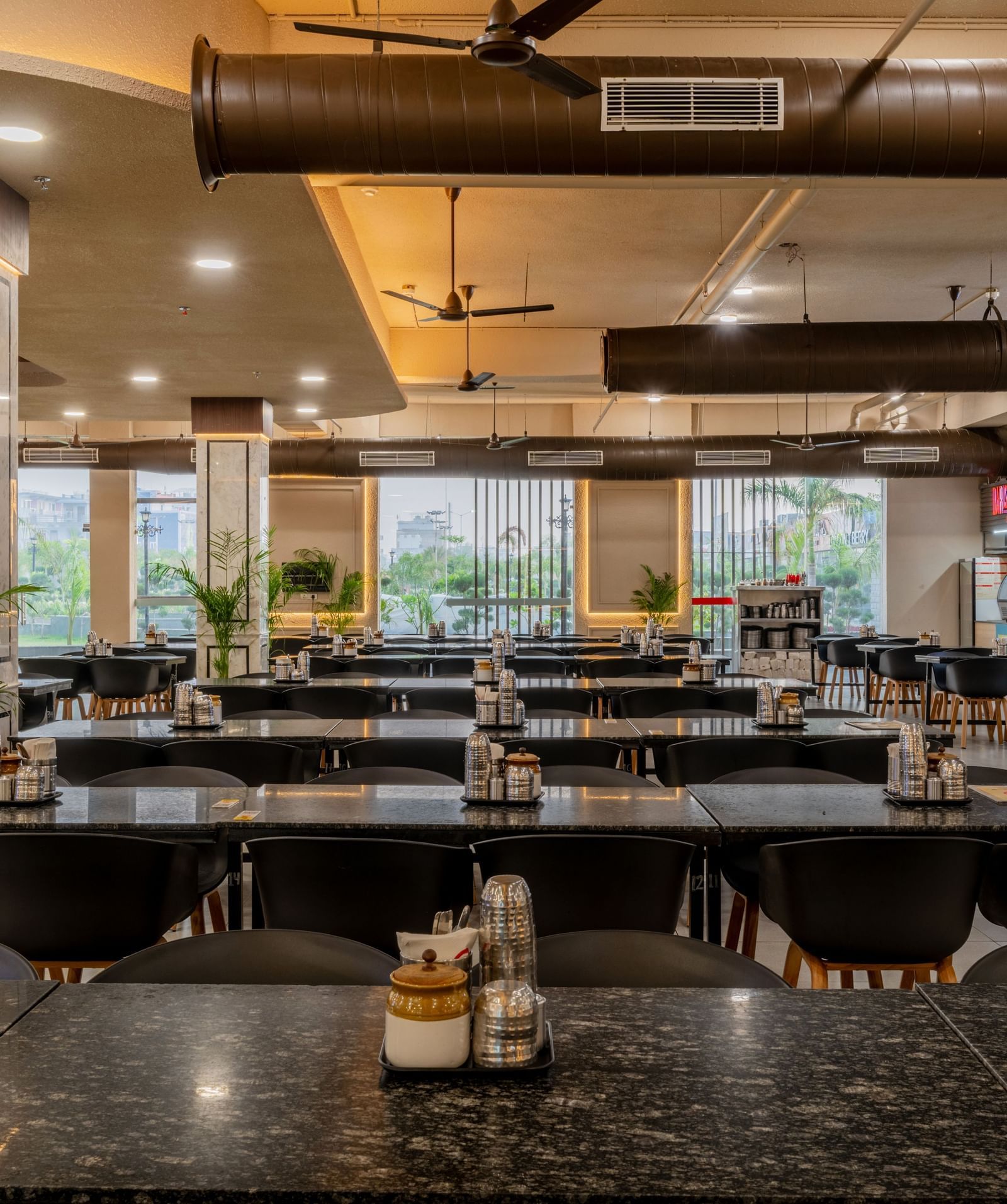 Stylish dining area with warm lighting and neatly set tables at Hotel Highway King, Neemrana.
