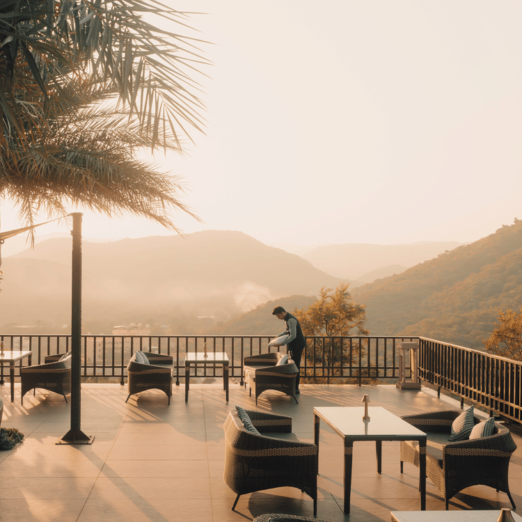 A couple enjoying a romantic evening at The Ananta Udaipur, with a stunning view of the Aravalli hills in the background.