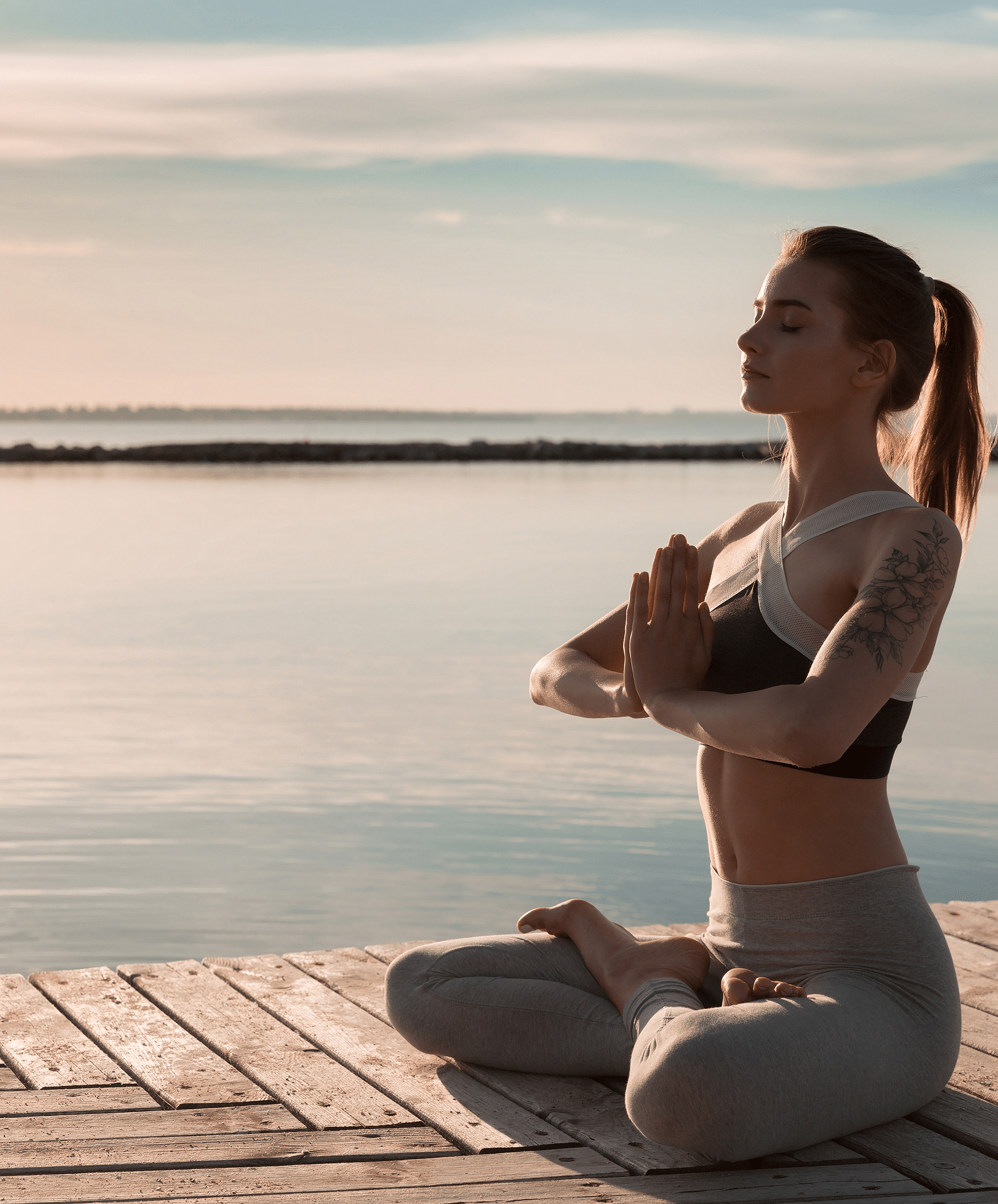 a woman meditating on a beach