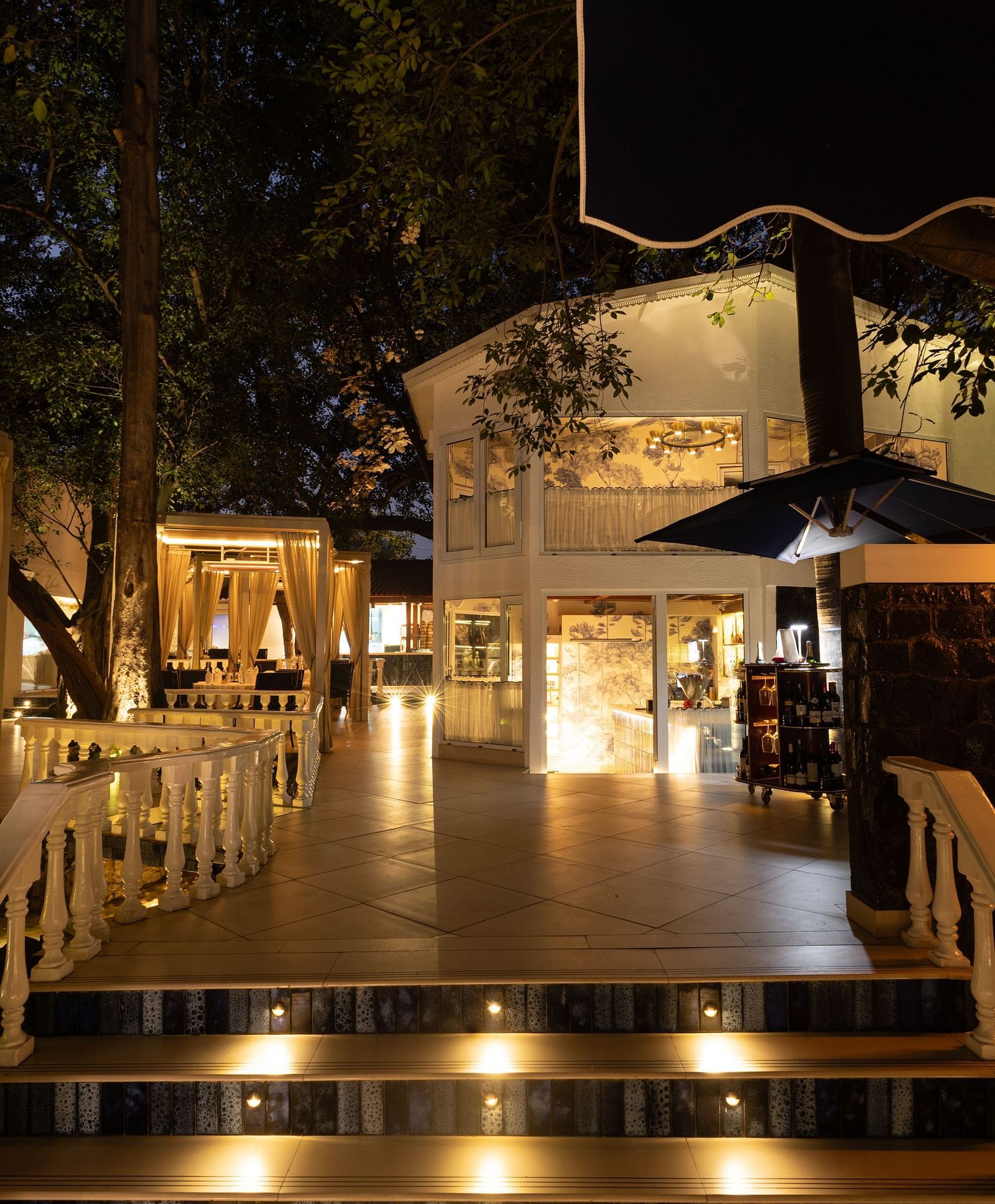Sevilla restaurant entrance at The Claridges New Delhi, beautifully illuminated at night, showcasing its charming alfresco and indoor dining spaces