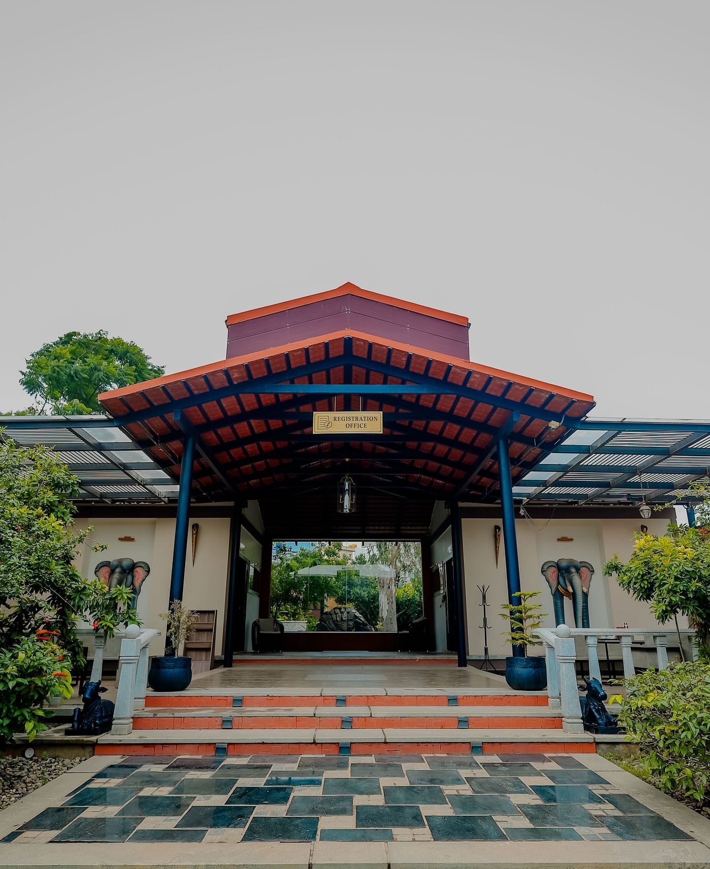 The entrance to a building with a tiled roof and steps leading up, possibly at Nirantara Resort & Spa in Bengaluru.