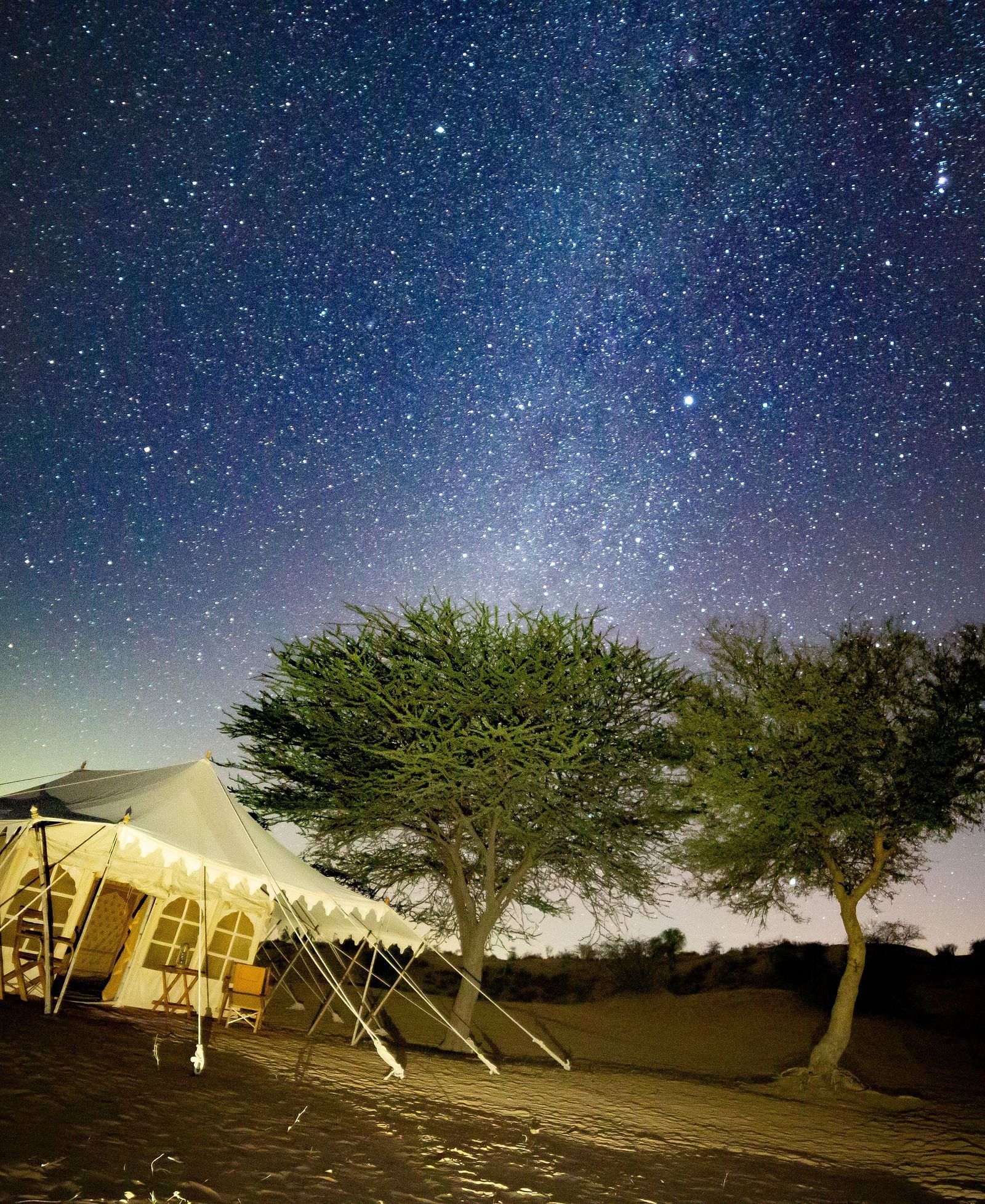 A breathtaking sunset view over the desert, with the campsite situated along the trail, highlighting the vastness of the landscape - MANVAR Resort & Desert Camp