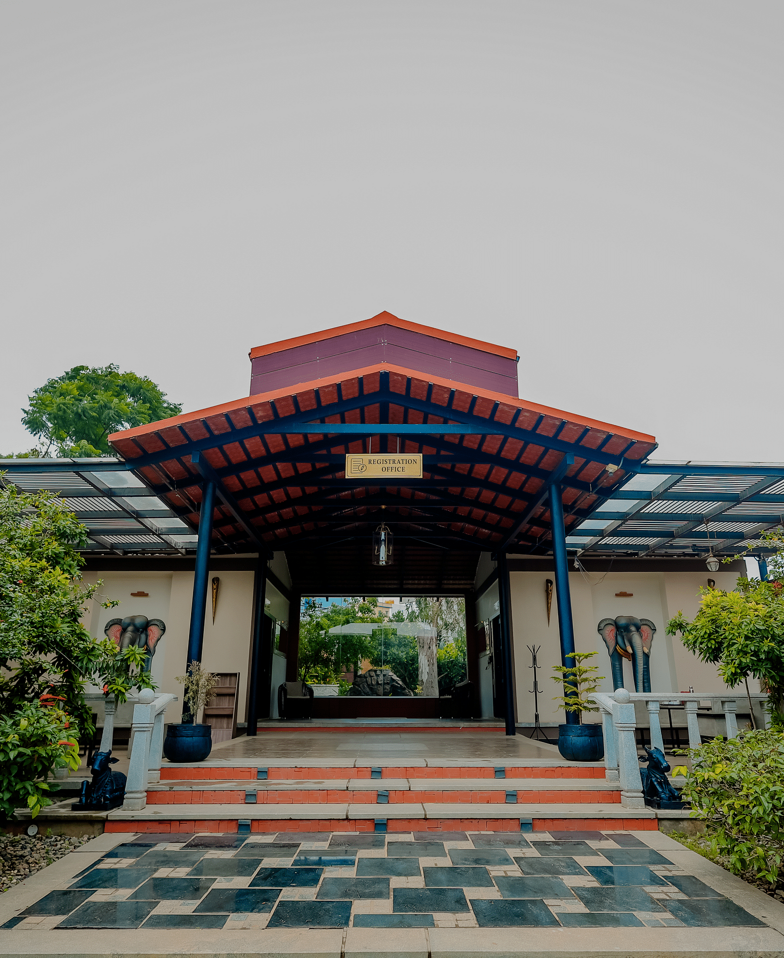 The entrance to a building with a tiled roof and steps leading up, possibly at Nirantara Resort & Spa in Bengaluru.