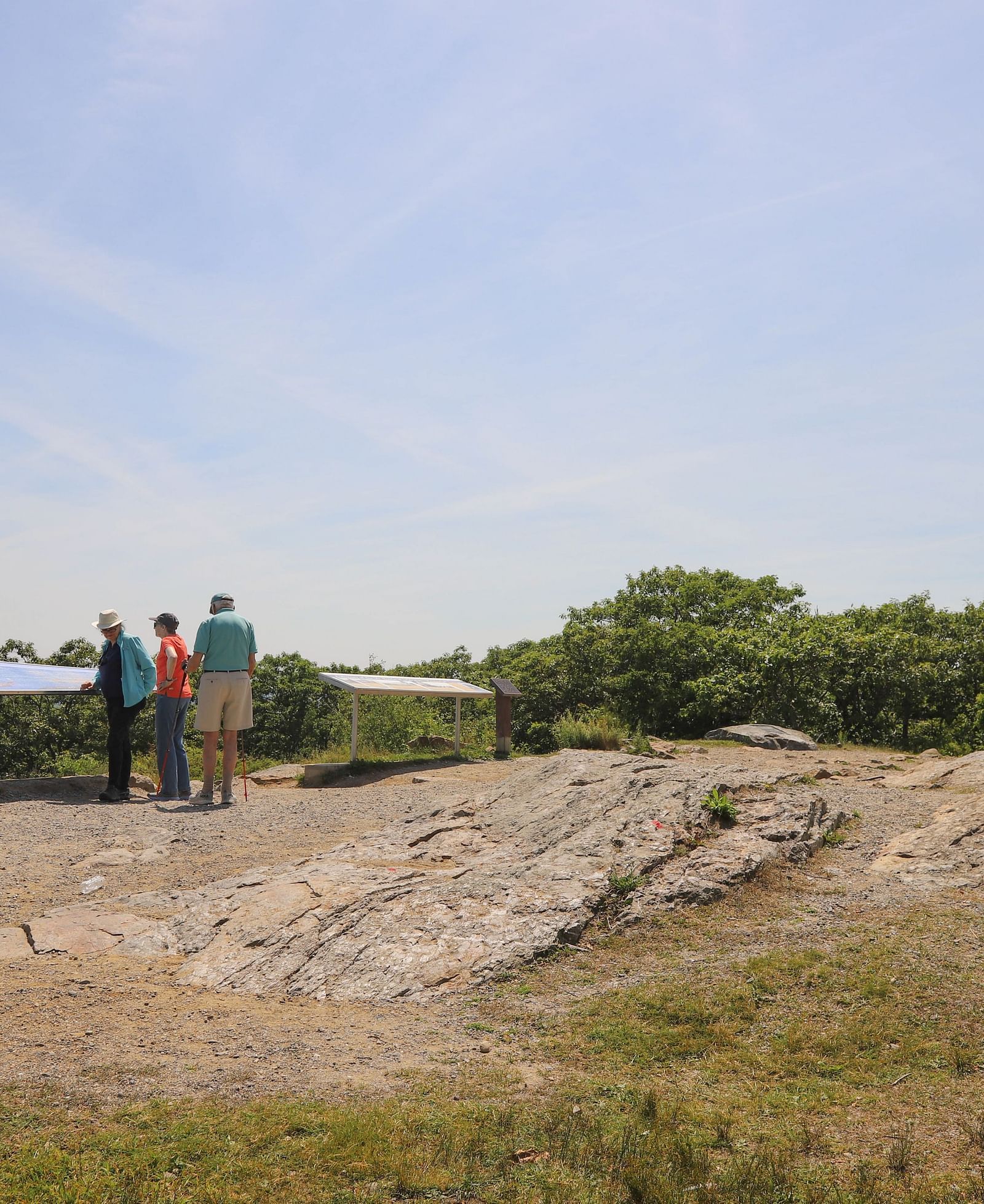 Visitors standing near a stone structure on a grassy hill near Hartstone Inn.