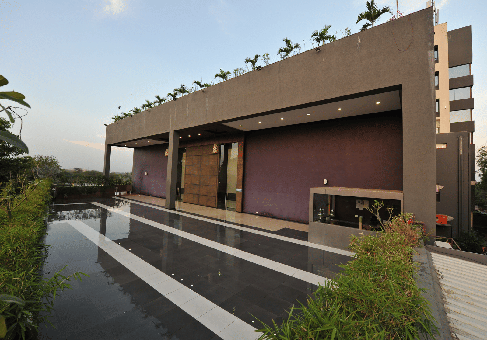 Exterior of a modern building with a sleek, minimalist design at Narayani Heights Hotel & Resorts, Ahmedabad.