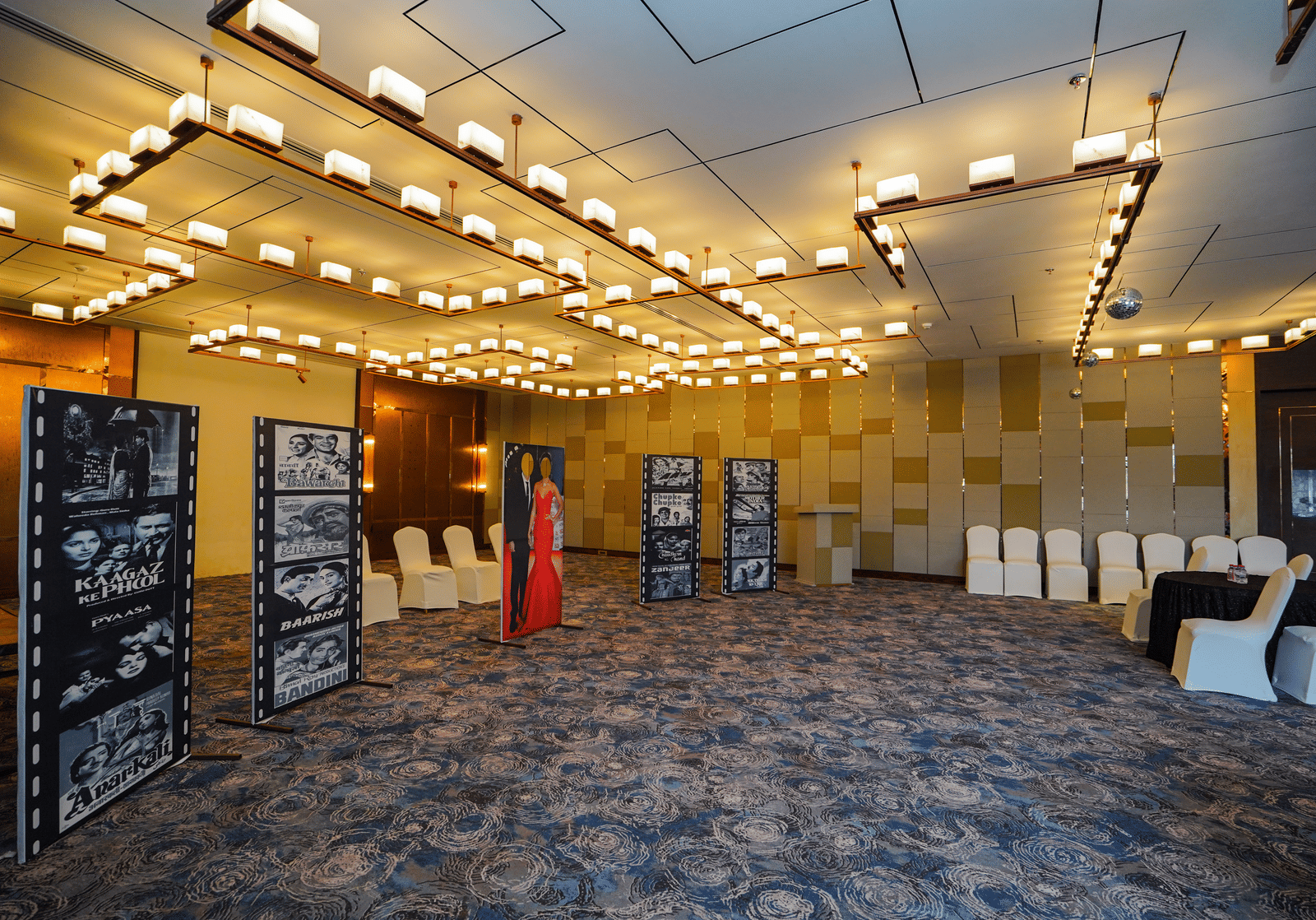 A wide-angle shot of an event space with rows of chairs and a few display boards, indicating a presentation or conference is about to begin.