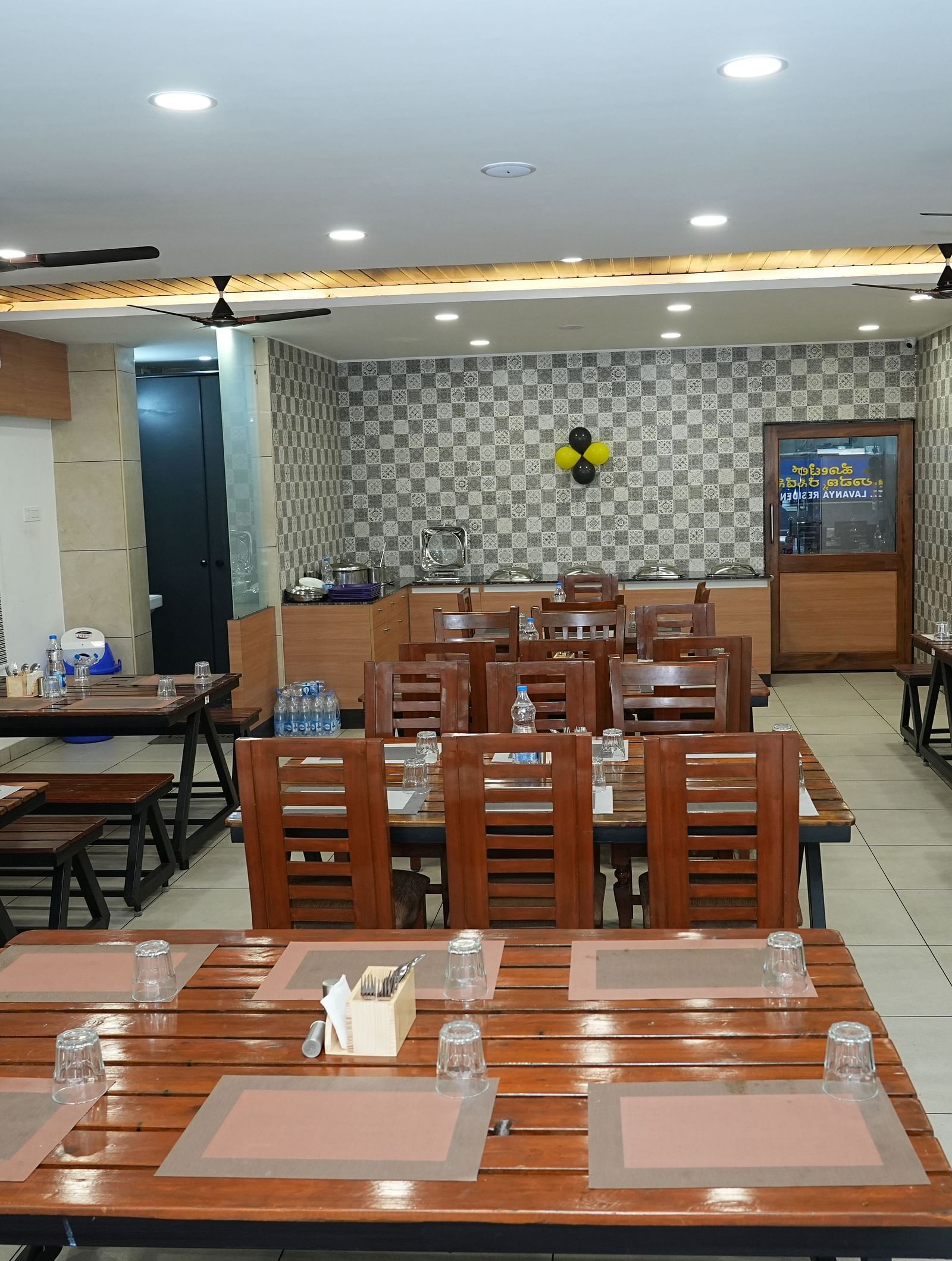 a top angle shot of the dining area featuring a table with six table mats placed over it - Hotel Grand Sigma
