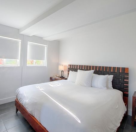 Bedroom at Casa Morada featuring a white bed, wooden furniture, and a wall-mounted TV.