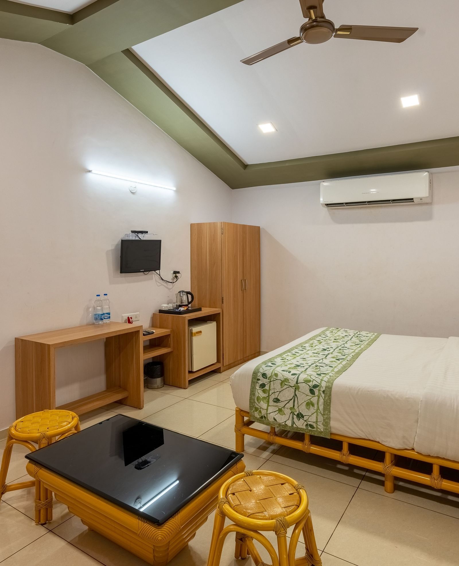 A room with a double bed, seating arrangement and work desk and chair