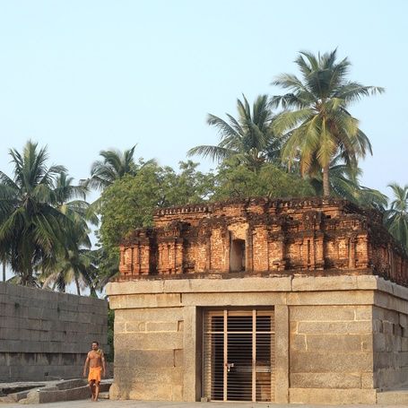 Badavilinga Temple ruins in Hampi with palm trees.
