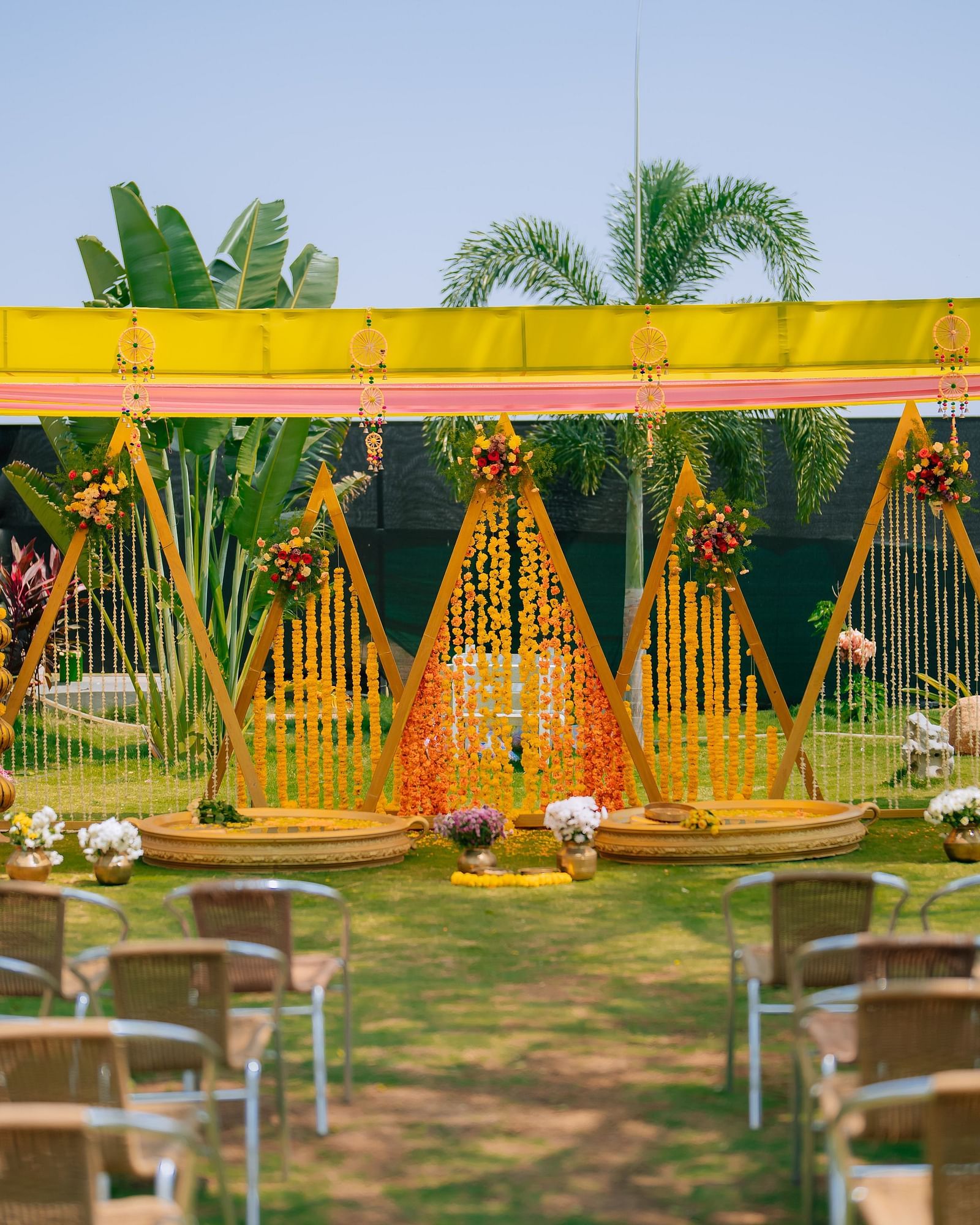 image of the decoration of haldi ceremony with several chairs placed facing towards the stage