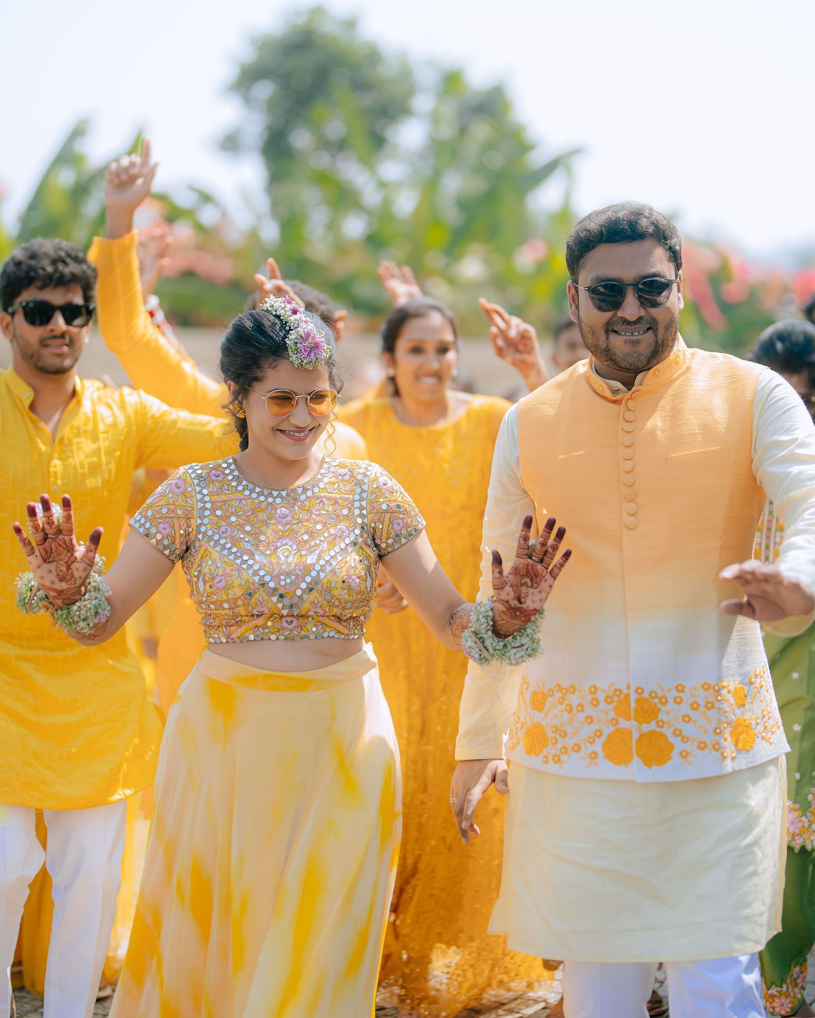 image featuring the couple with their freinds and family dancing in the background with yellow colour as the dress code at darza resorts