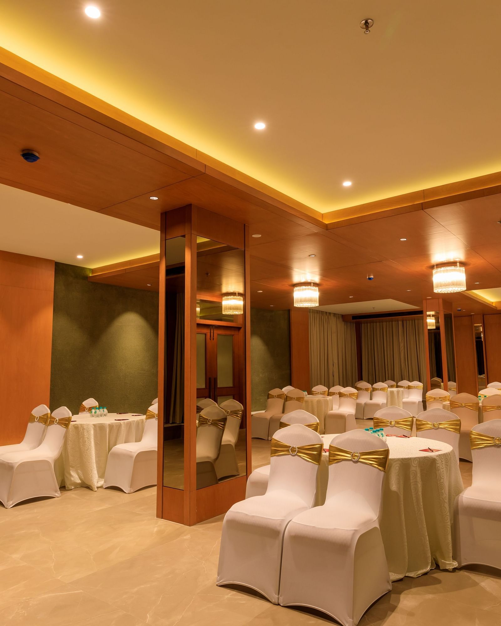 A softly lit function room at Lords Eco Inn Apple Gate is arranged with round tables and covered chairs, ready for an event.