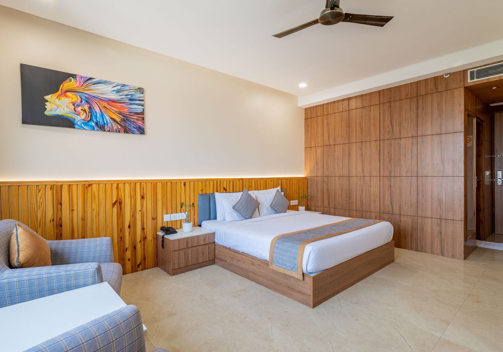 Club room with double bed, lounge chairs, and ceiling fan at Hotel Highway King, Bagru