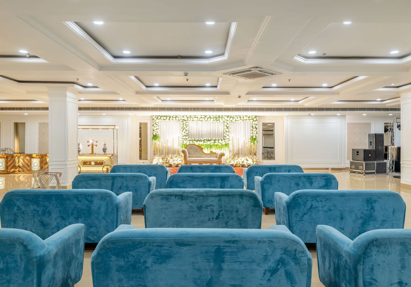 Comfortable blue lounge seating in a large, elegant banquet hall at Hotel Highway King, Bilaspur.