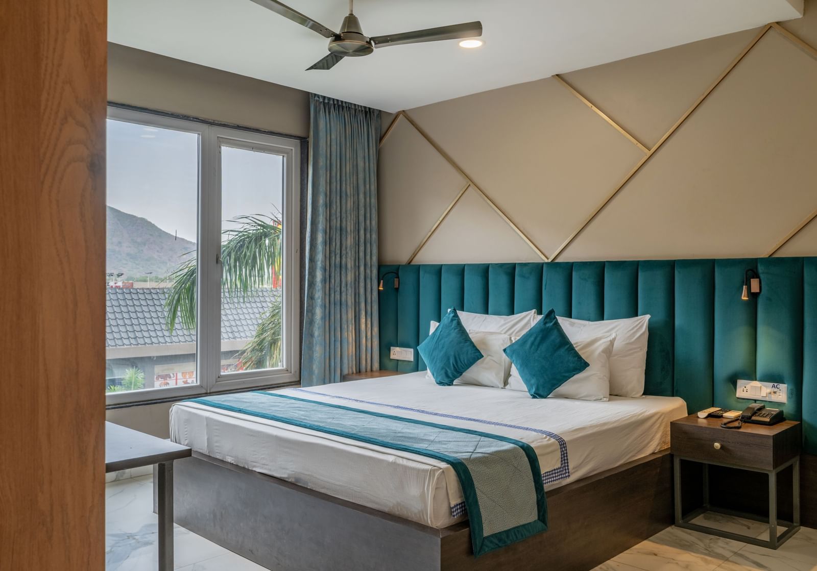 Another view of a stylish guest room featuring a comfortable bed and modern decor at Hotel Highway King Shahpura.