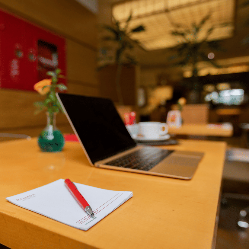 A close up shot of a table with a writing pad, pen and a laptop - Ramada by Wyndham Addis, Addis Ababa
