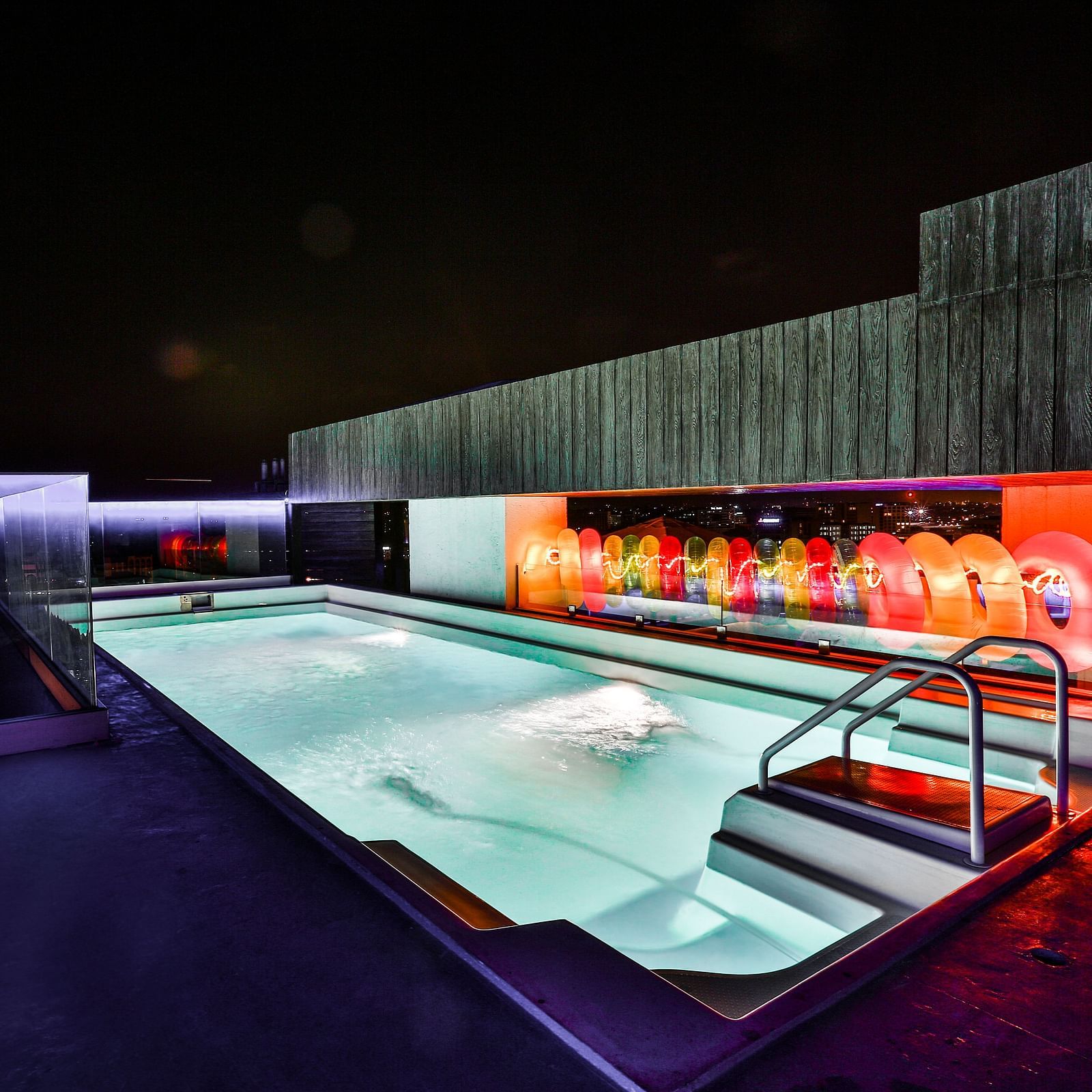 A well-lit rooftop swimming pool at T24 Residency, Andheri East, Mumbai at night