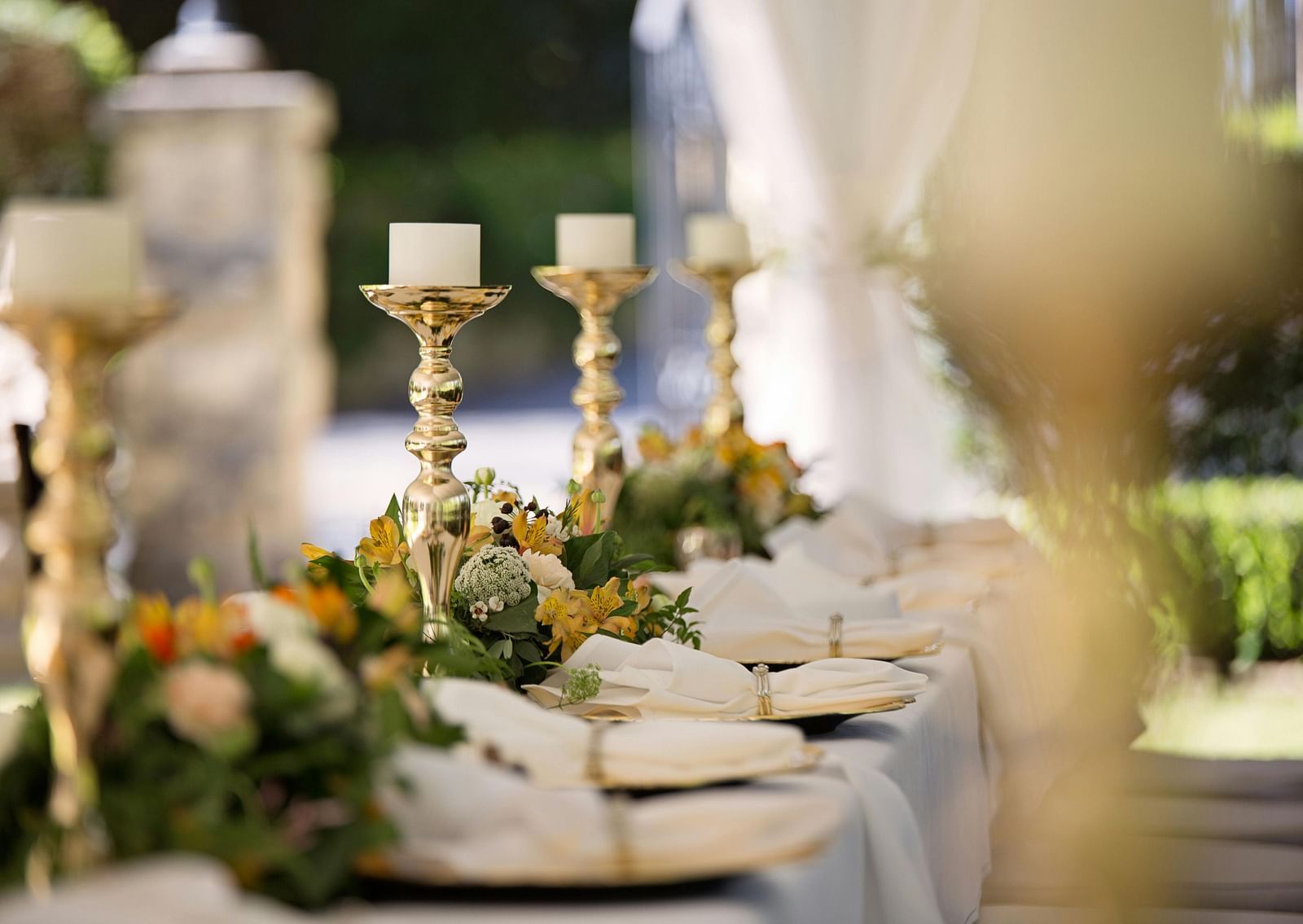 Selective focus of candlesticks on table with wedding set-up