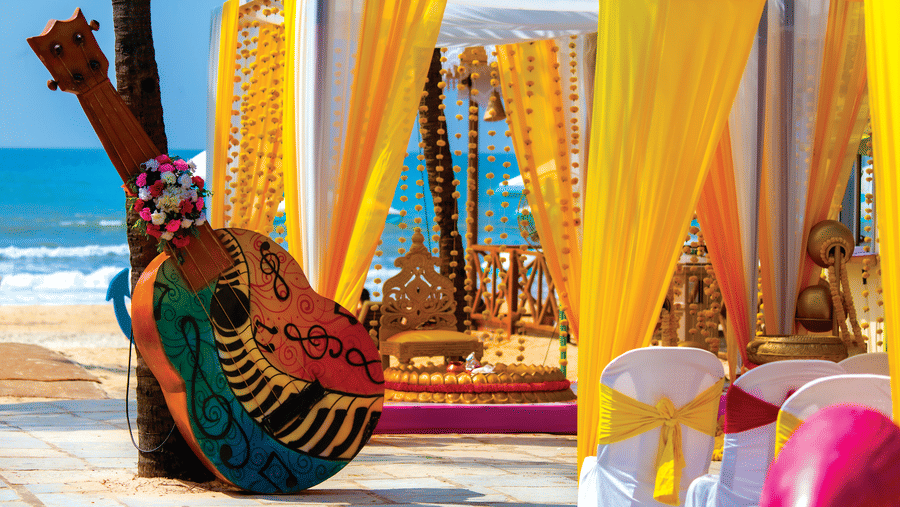 a decorated cabana with a guitar leaning on a tree - Caravela Beach Resort Goa