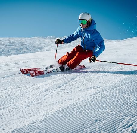 A person skiing down a snow-covered slope.
