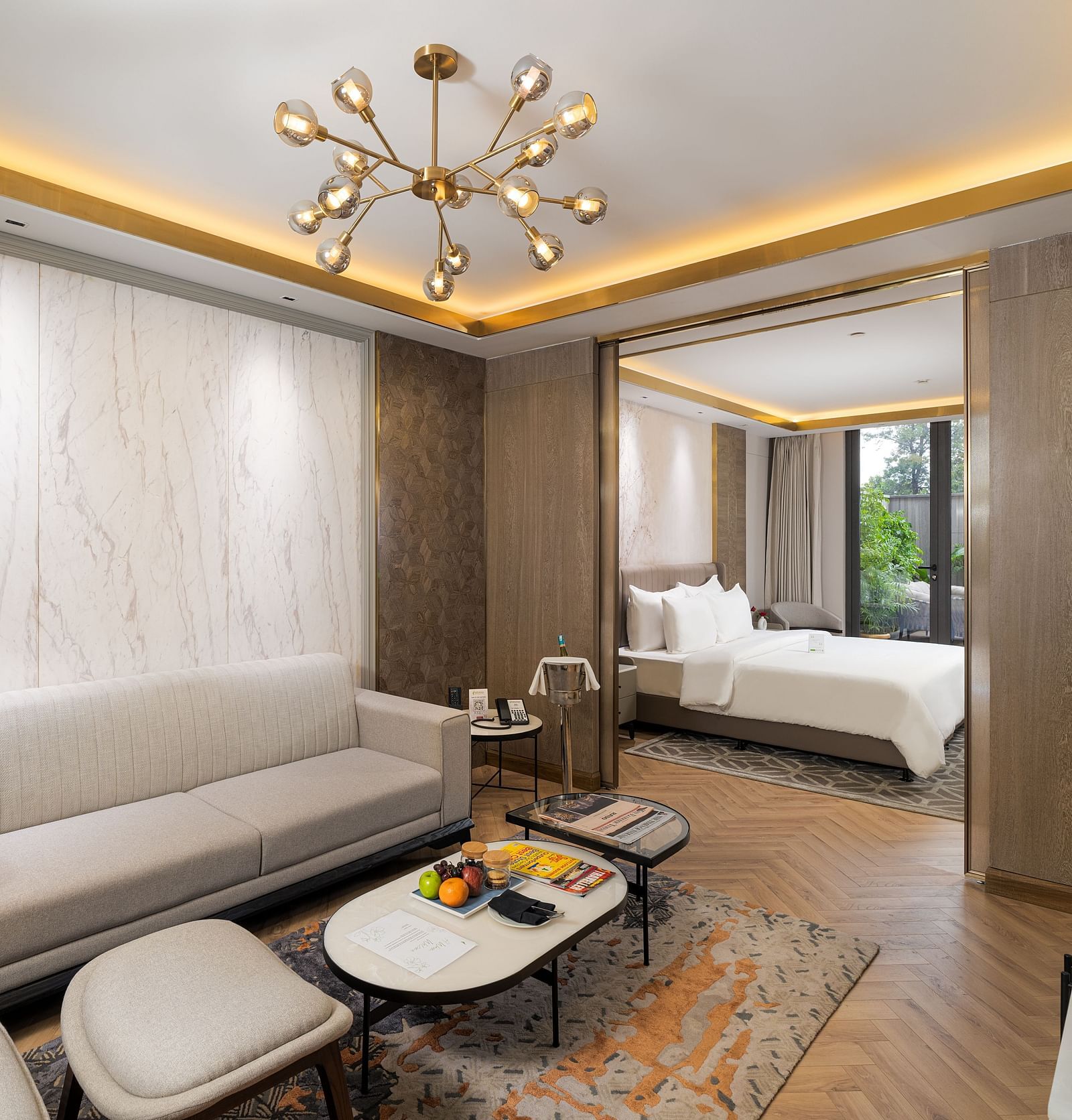 Nirvana Suite living area with a stylish sofa, a chic coffee table, and an open view into the spacious bedroom - Nirvana Luxury Hotel, Ludhiana