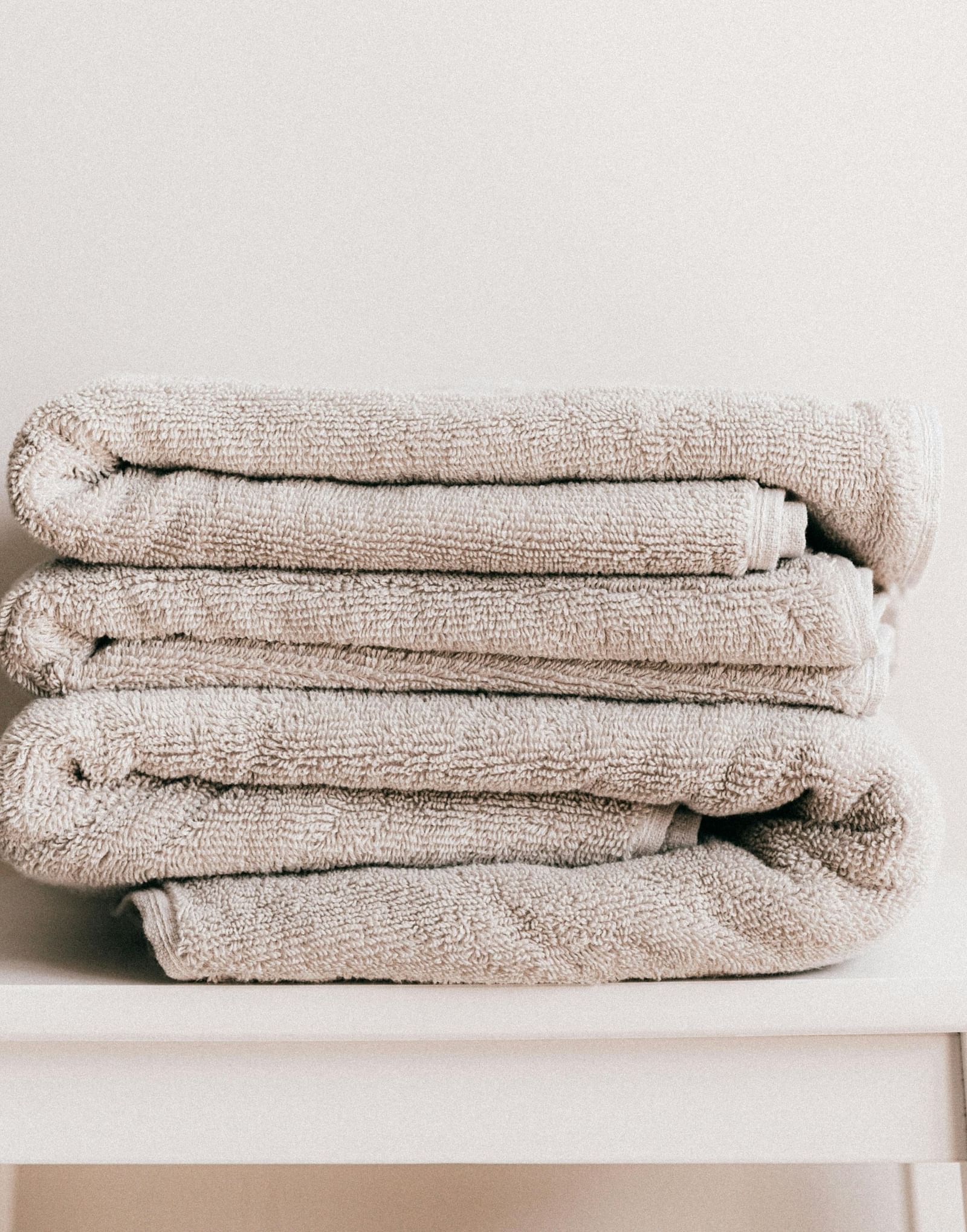A few white towels neatly folded and kept on a stool.