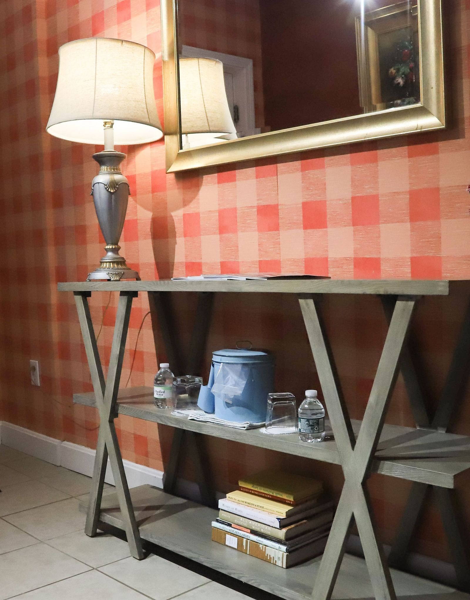 Room with checked wallpaper, a mirror on the wall, and lamp on the table at Hartstone Inn.