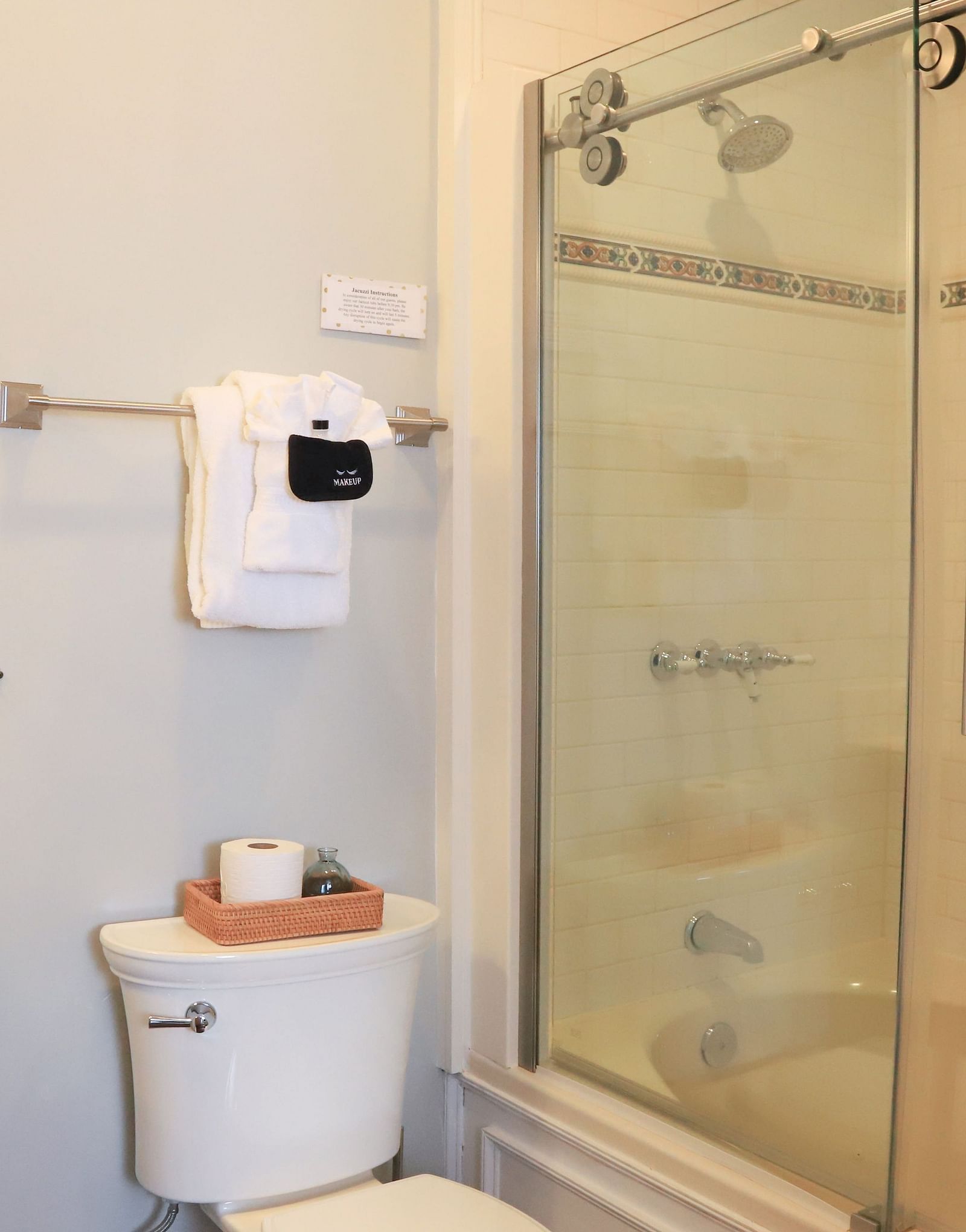Bathroom with glass-walled shower area, small mirror, sink, and tissue roll placed near the toilet area at Hartstone Inn.