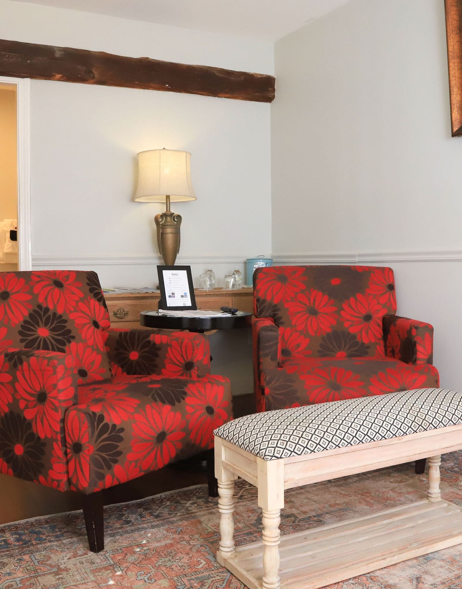 Seating area with two red patterned chairs and a table at Hartstone Inn.