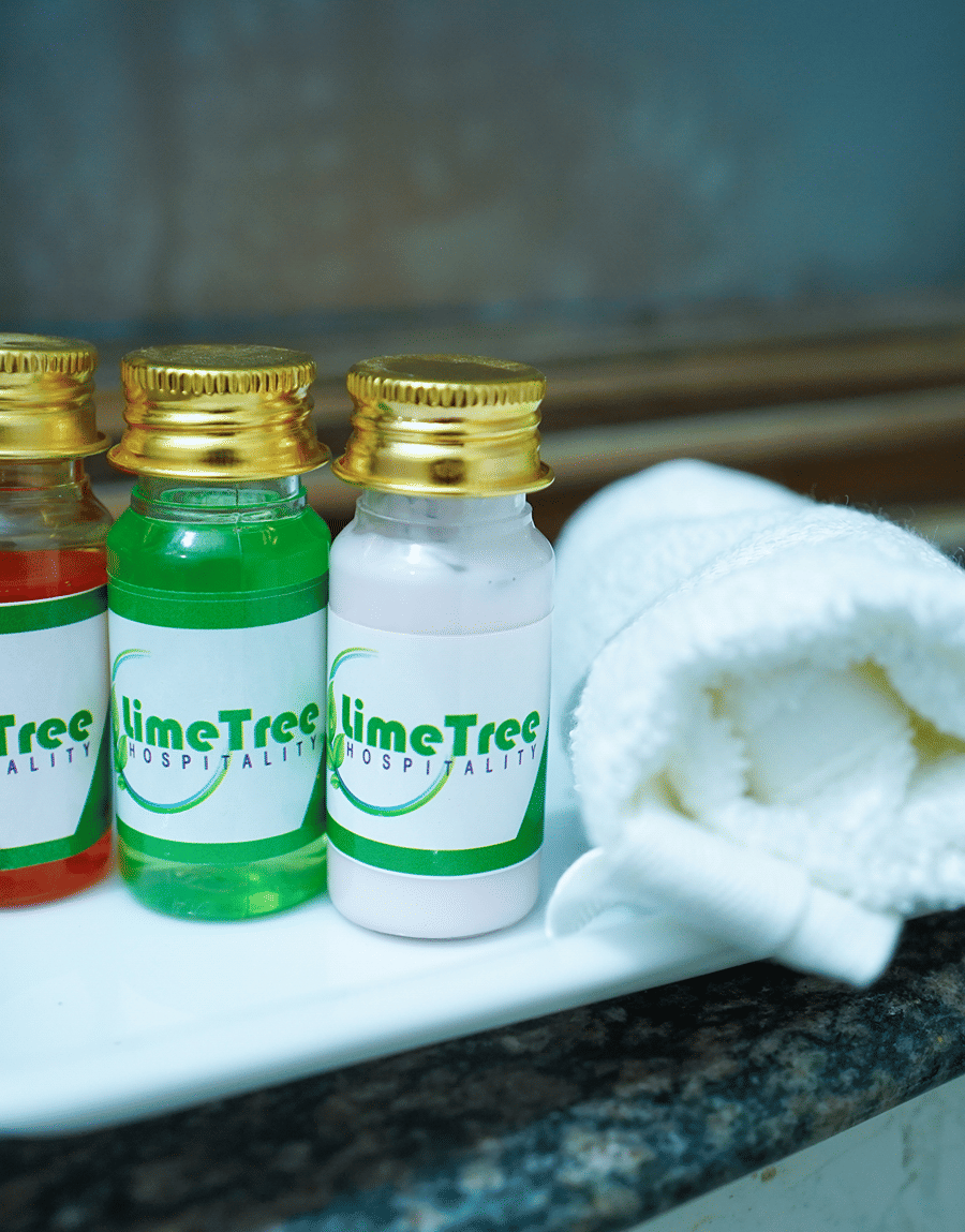 Lime Tree branded toiletries and a folded towel in the Superior King Room bathroom at Lime Tree Hotel Near 32nd Avenue