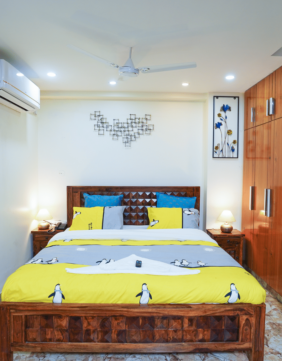 Superior King Room with a wooden bed, yellow bedding and a wooden wardrobe at Lime Tree Hotel Near 32nd Avenue
