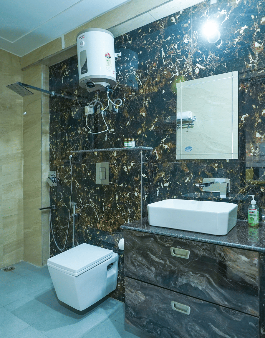 Bathroom with dark marble tiles, a vessel washbasin and a geyser in the Superior King Room, Lime Tree Hotel Near 32nd Avenue