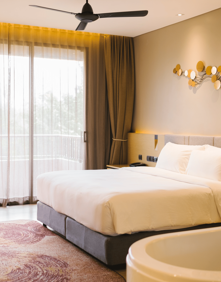 Bright room with a double bed, a ceiling fan and large windows opening onto a balcony