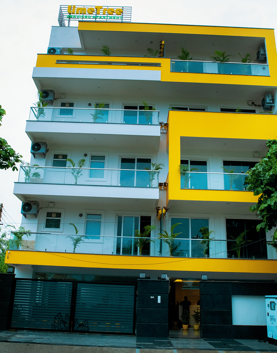 Exterior of Lime Tree Luxury Studio, a white and yellow building with glass balconies in Sector 51, Gurgaon