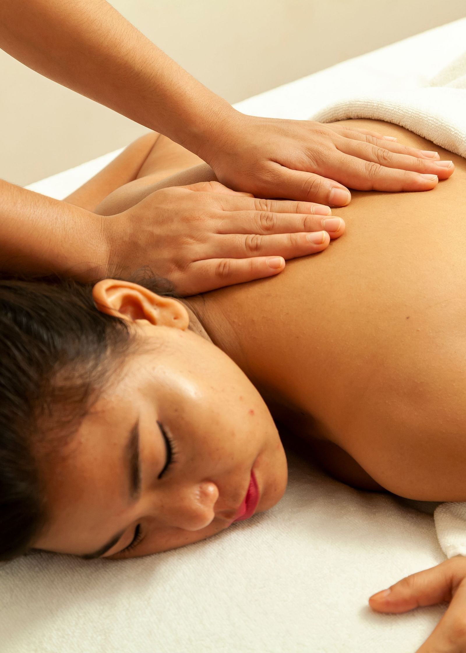 a woman getting a back massage while sleeping on the massage table - Caravela Beach Resort Goa