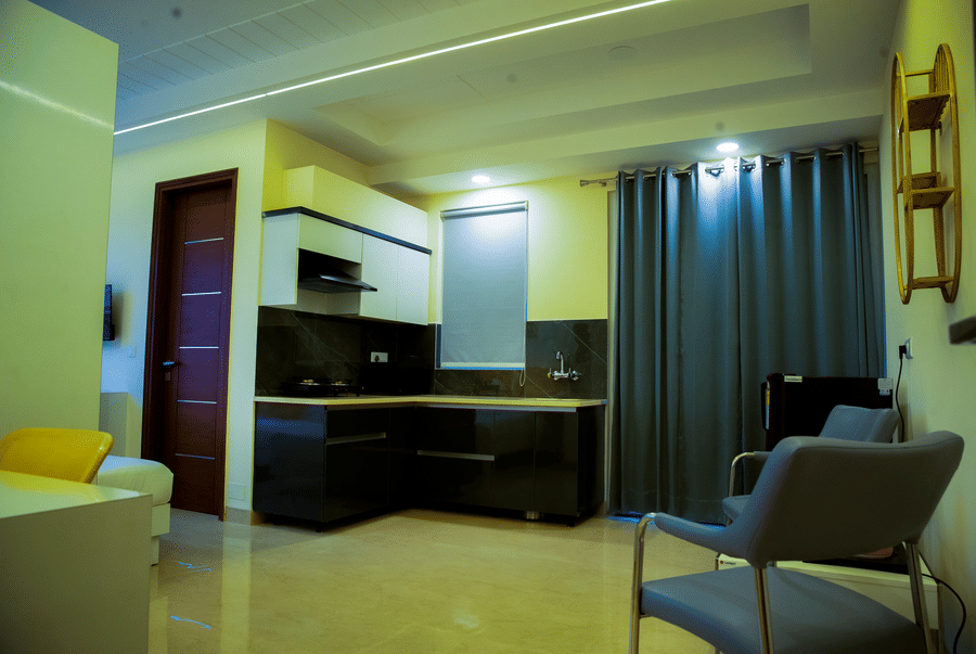 Studio with an open kitchen, grey curtains and an armchair at Lime Tree Luxury Studio, Gurgaon