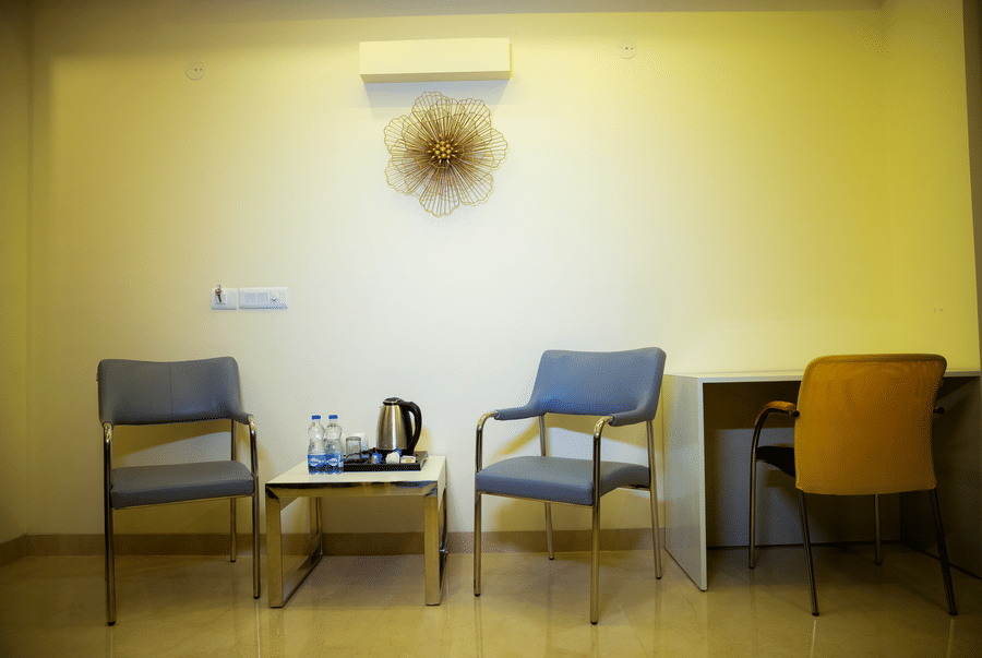 Two chairs, a tea tray with a kettle and a work desk in a studio at Lime Tree Luxury Studio, Gurgaon