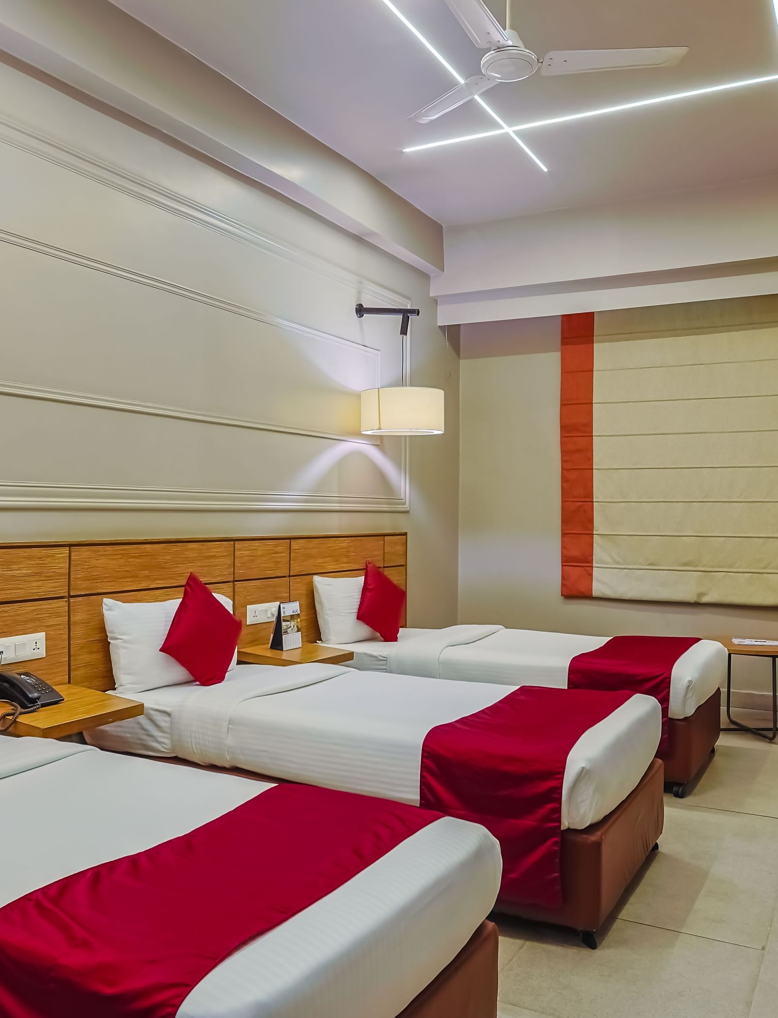 Spacious room with three single beds and modern design at Max Hotel Prayagraj.