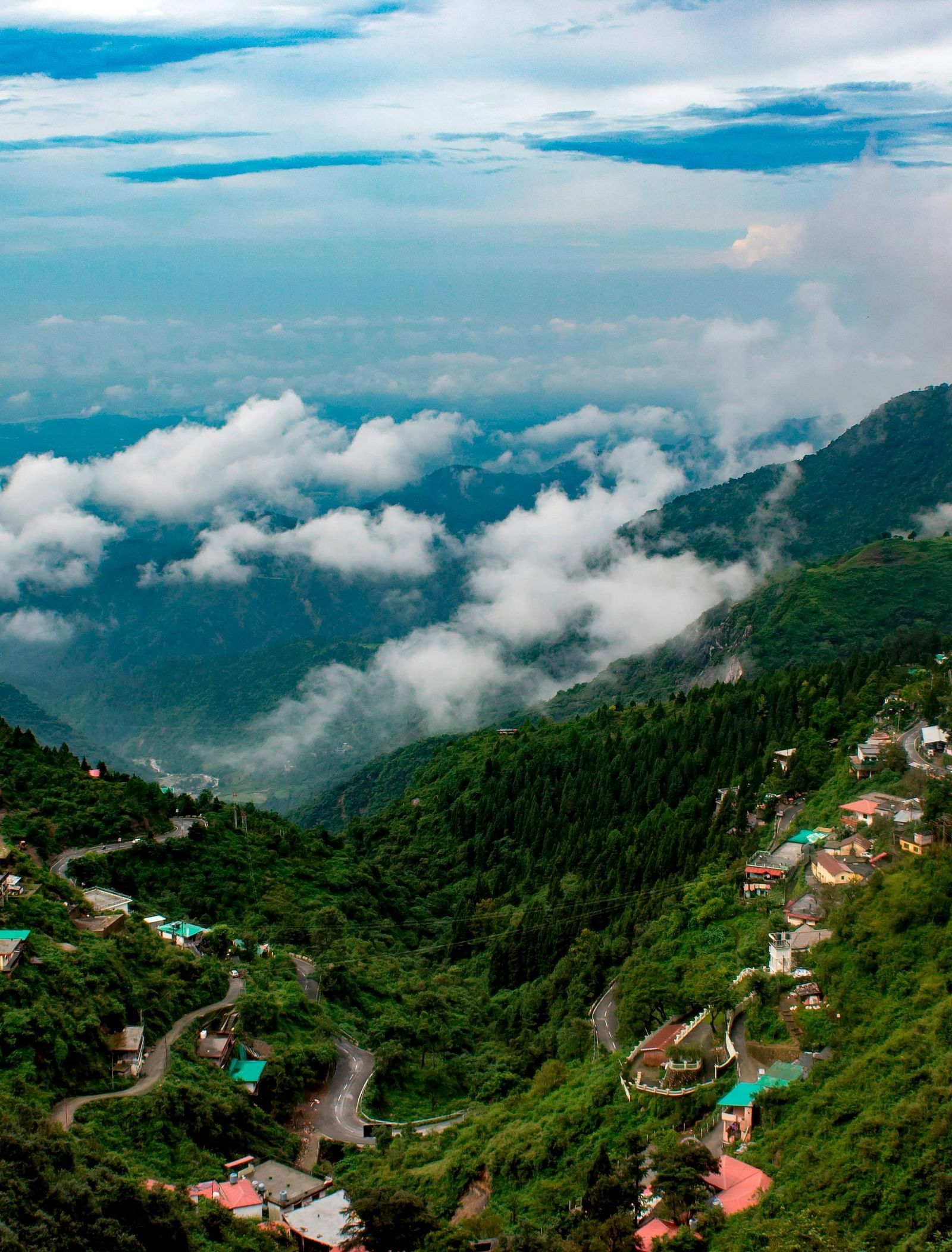 a serene landscape of mussoorie with clouds in the sky