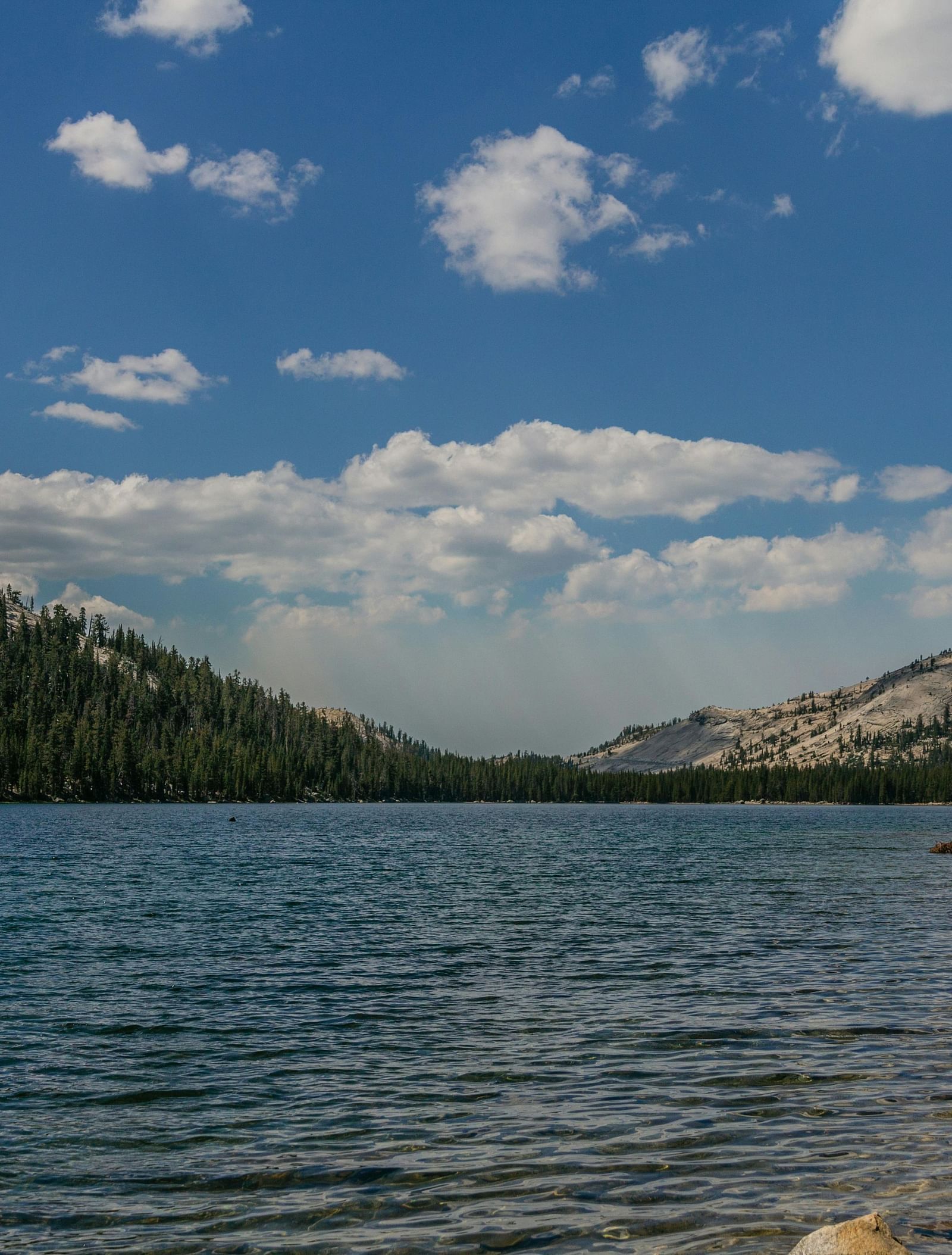 A view of a lake with mountains in the backdrop during the day