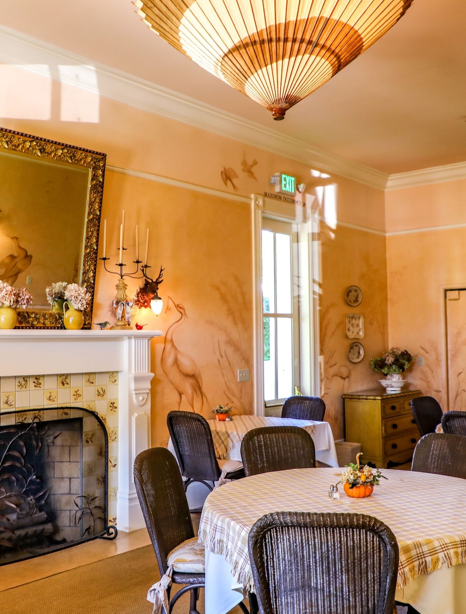 The Tallman Hotel features a dining area with peach walls, a fireplace with a mirror, and a display cabinet.