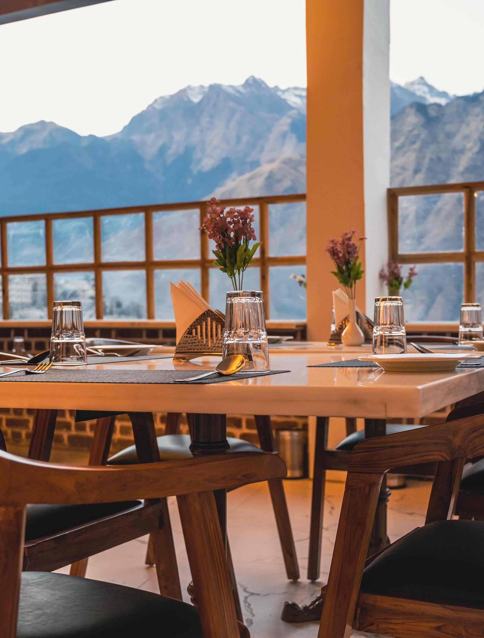 image of the indoor dining area of the alpenrose restaurant featuring a table over looking the beautiful mountain views - the tattva boutique resort