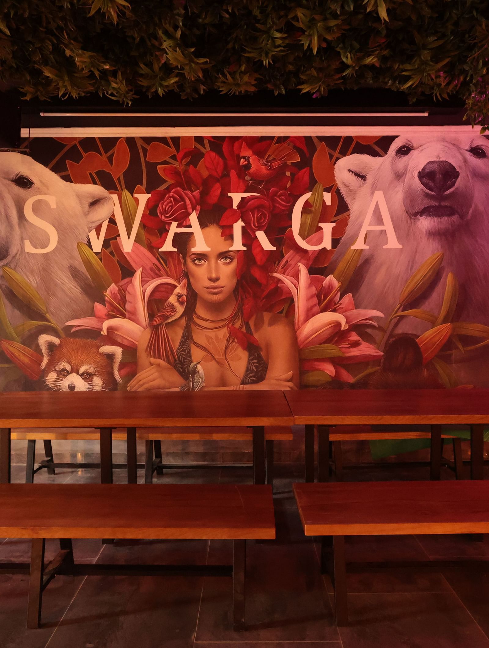 A large wooden table with seating in front of a postered wall | Cenneys Gateway