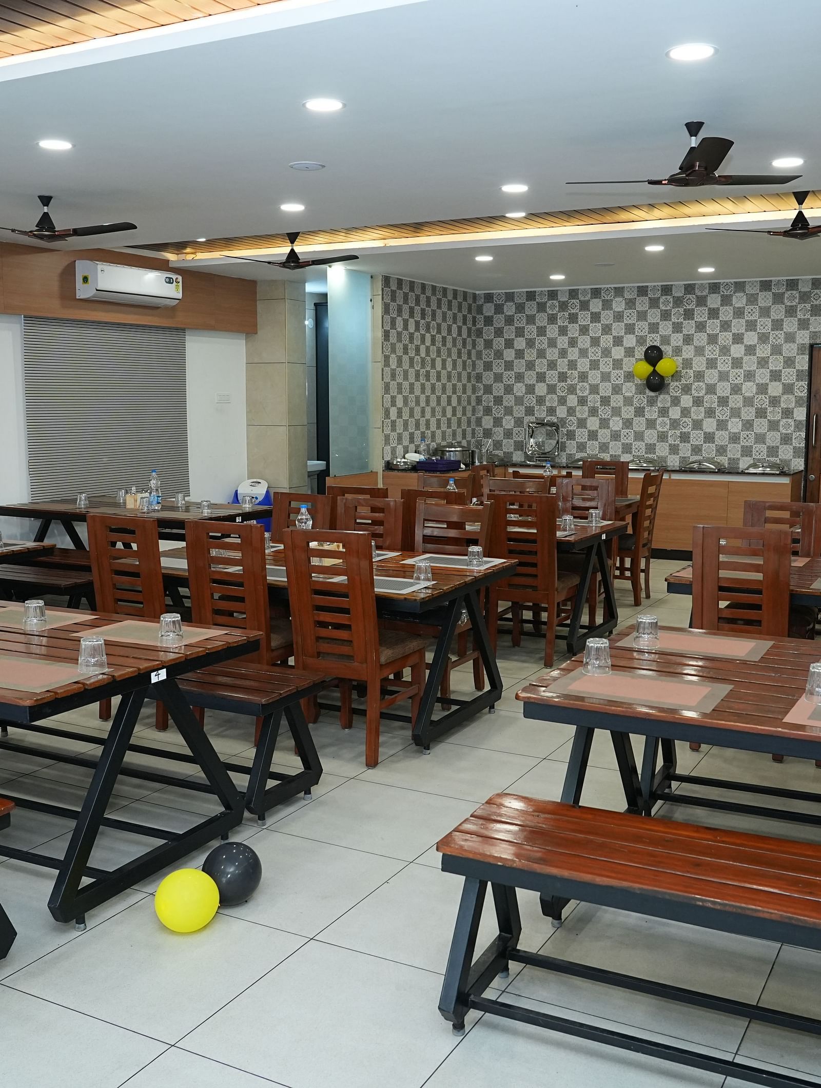 full view image of the dining area with wooden benches for sitting around the table - Hotel Grand Sigma