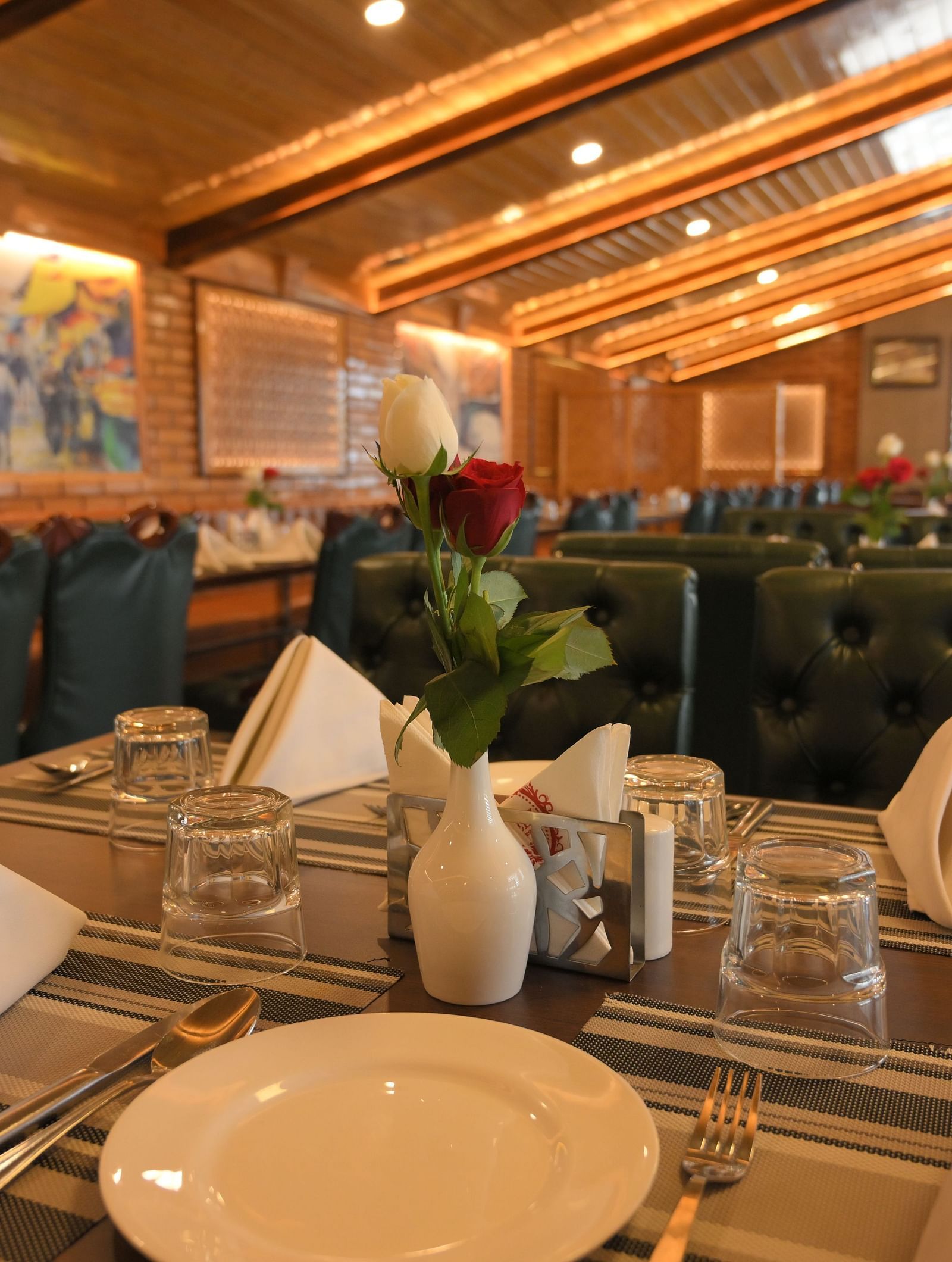 Elegant dining table setup with crisp napkins and warm lighting at Royal Comfort Regency, perfect for a refined dining experience.